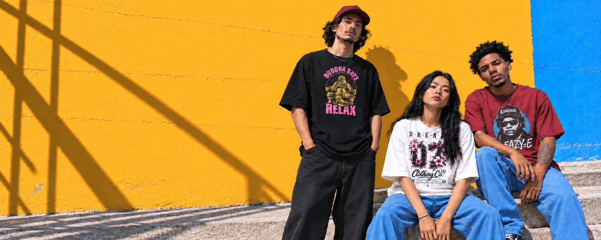 Drie modellen in grafische T-shirts tegen een gele en blauwe muur